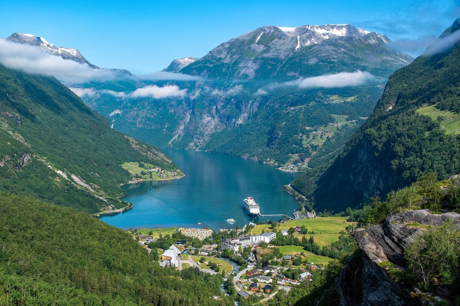 Atemberaubende Fjordlandschaft in Norwegen mit tiefblauem Wasser und schneebedeckten Bergen.