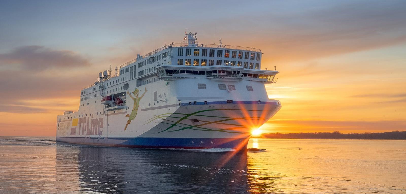 Große Fähre bei Sonnenaufgang auf offenem Meer, goldener Himmel, ruhige See.