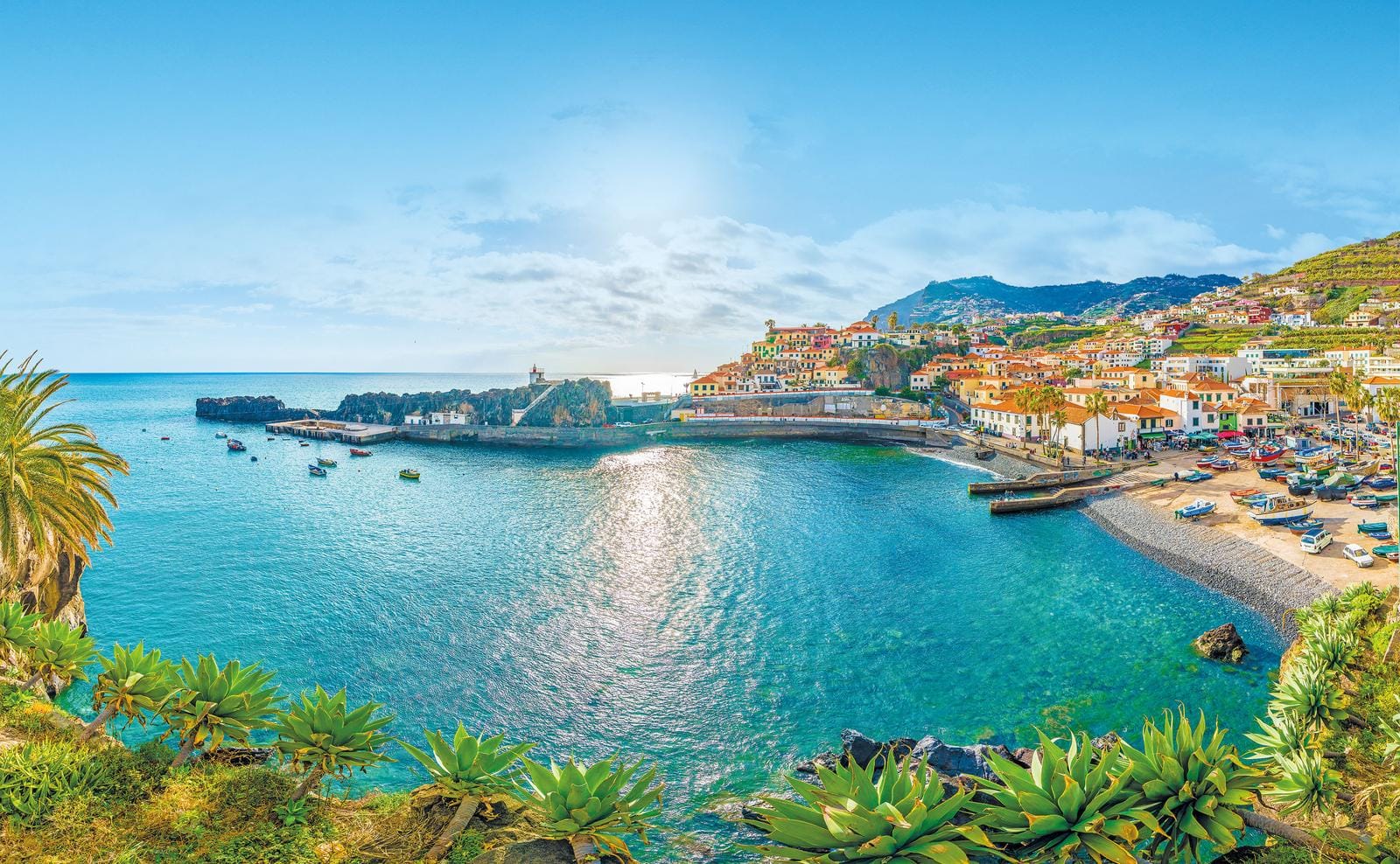 Bunte Häuser und klares Wasser in Madeira, Portugal; idyllische Küstenlandschaft voller Charme.