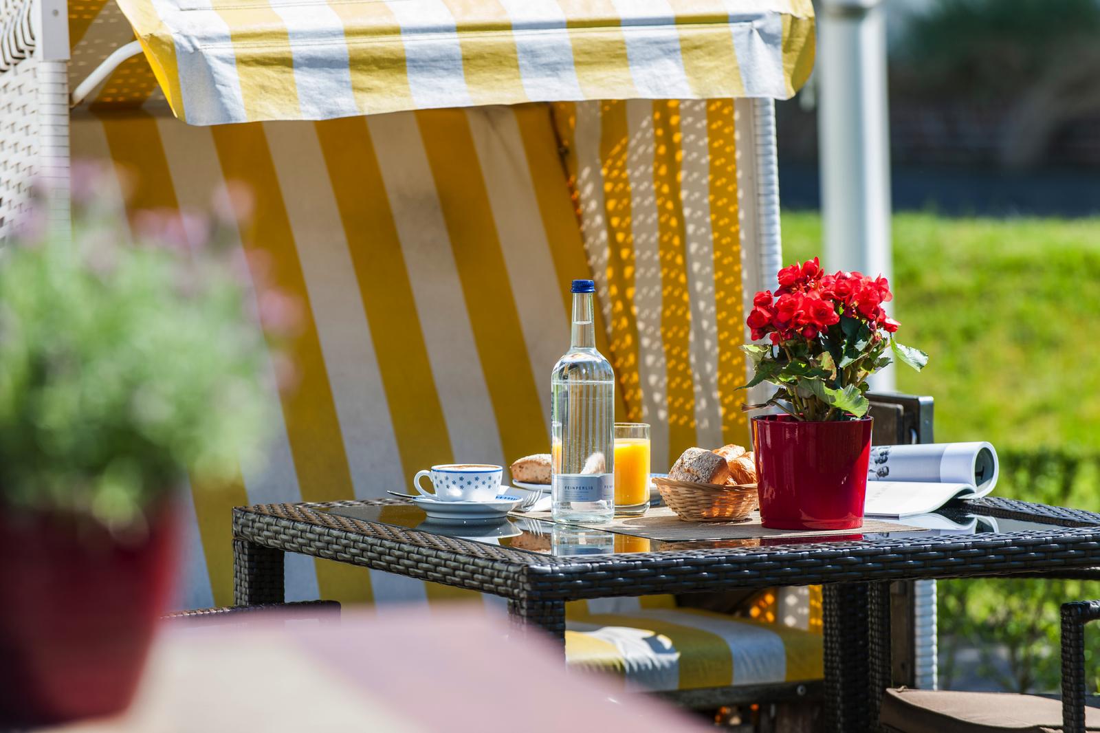 Frühstück im Strandkorb, typisch Nordsee-Deutschland, mit Saft, Kaffee und Brötchen.