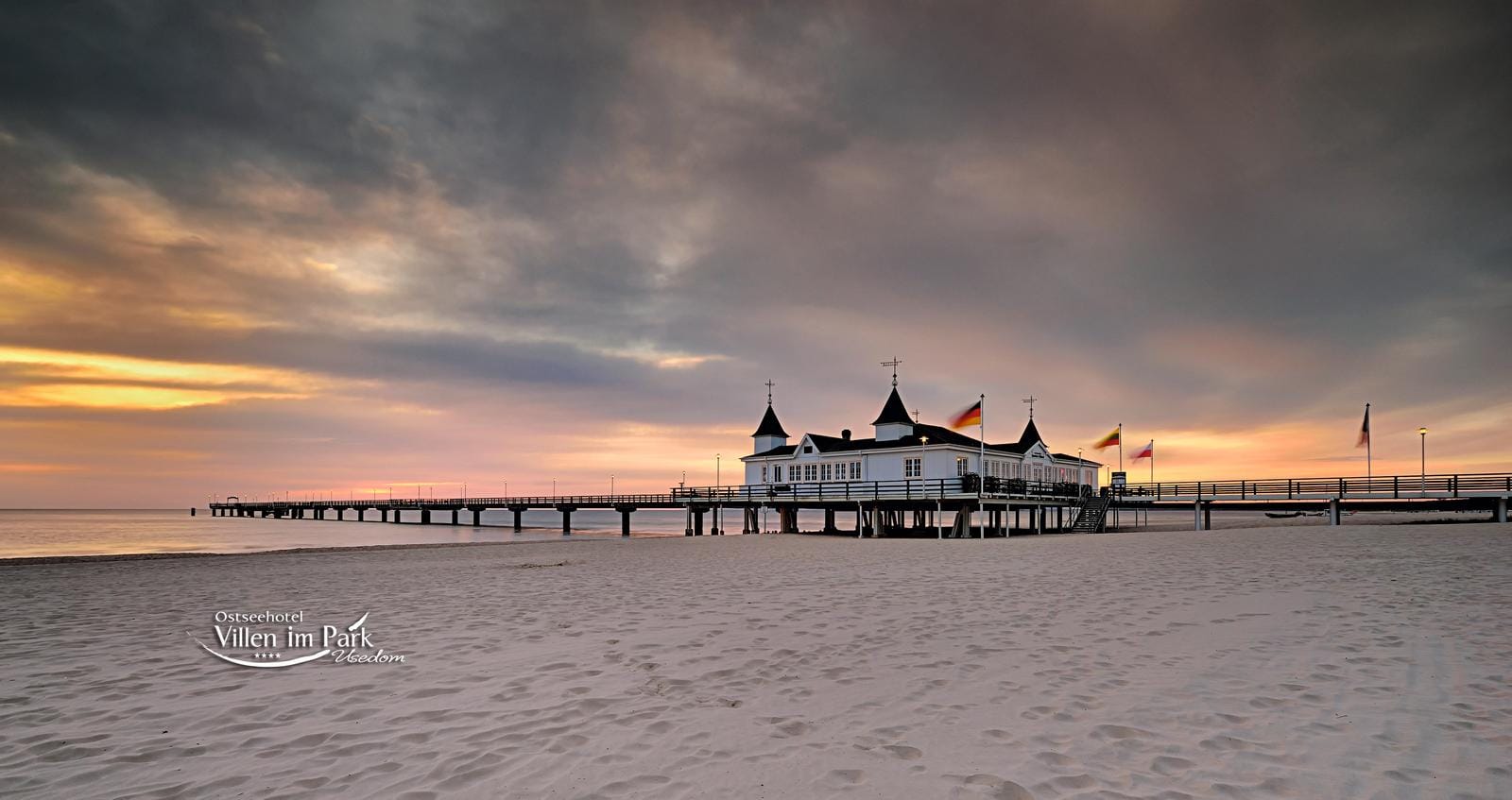 Abendstimmung am Strand von Usedom, Deutschland, mit stimmungsvoller SeebrĂĽcke im Sonnenuntergang.